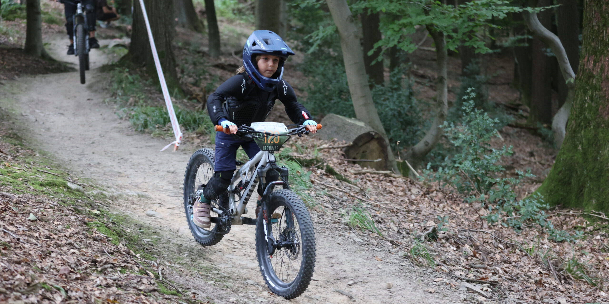 Auf einem Mountainbike Trail fahren Personen auf einem Fahrrad.