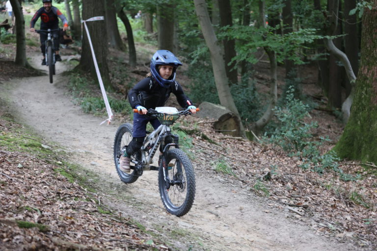 Auf einem Mountainbike Trail fahren Personen auf einem Fahrrad.