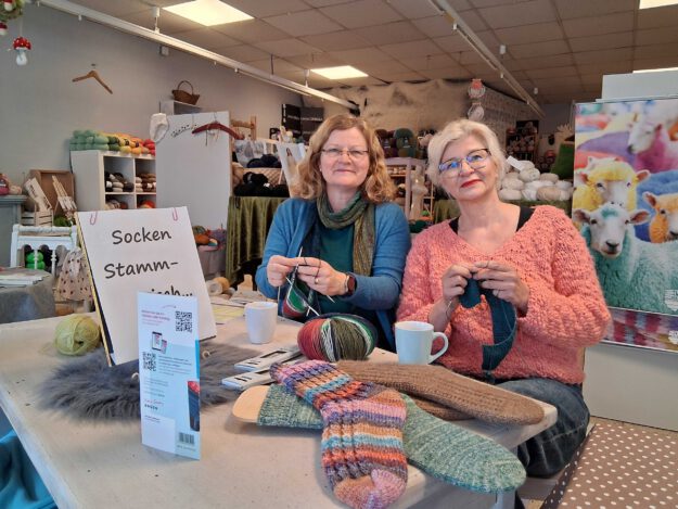 Foto: Ilka Kremer Zwei Frauen stehen in einem Geschäft und sticken mit Wolle.