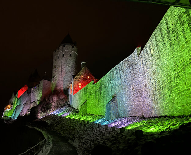 Foto: Märkischer Kreis Die Fassade der Burg Altena wird bei Nacht bunt beleuchtet.