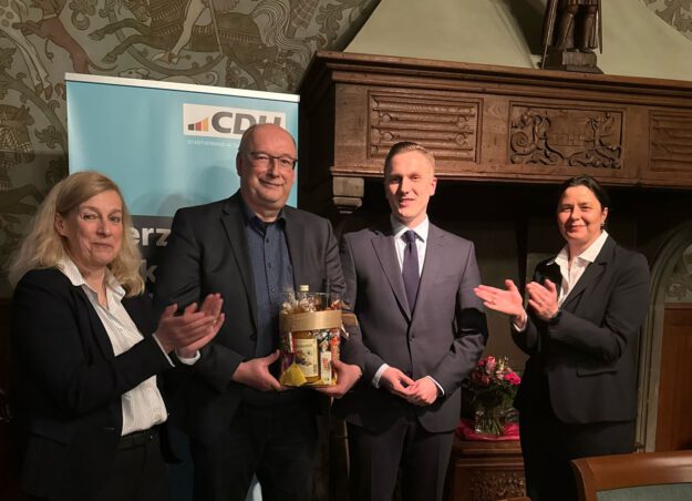 Foto: CDU-Stadtverband CDU-Politiker stehen in einem Raum vor einem Werbebanner.