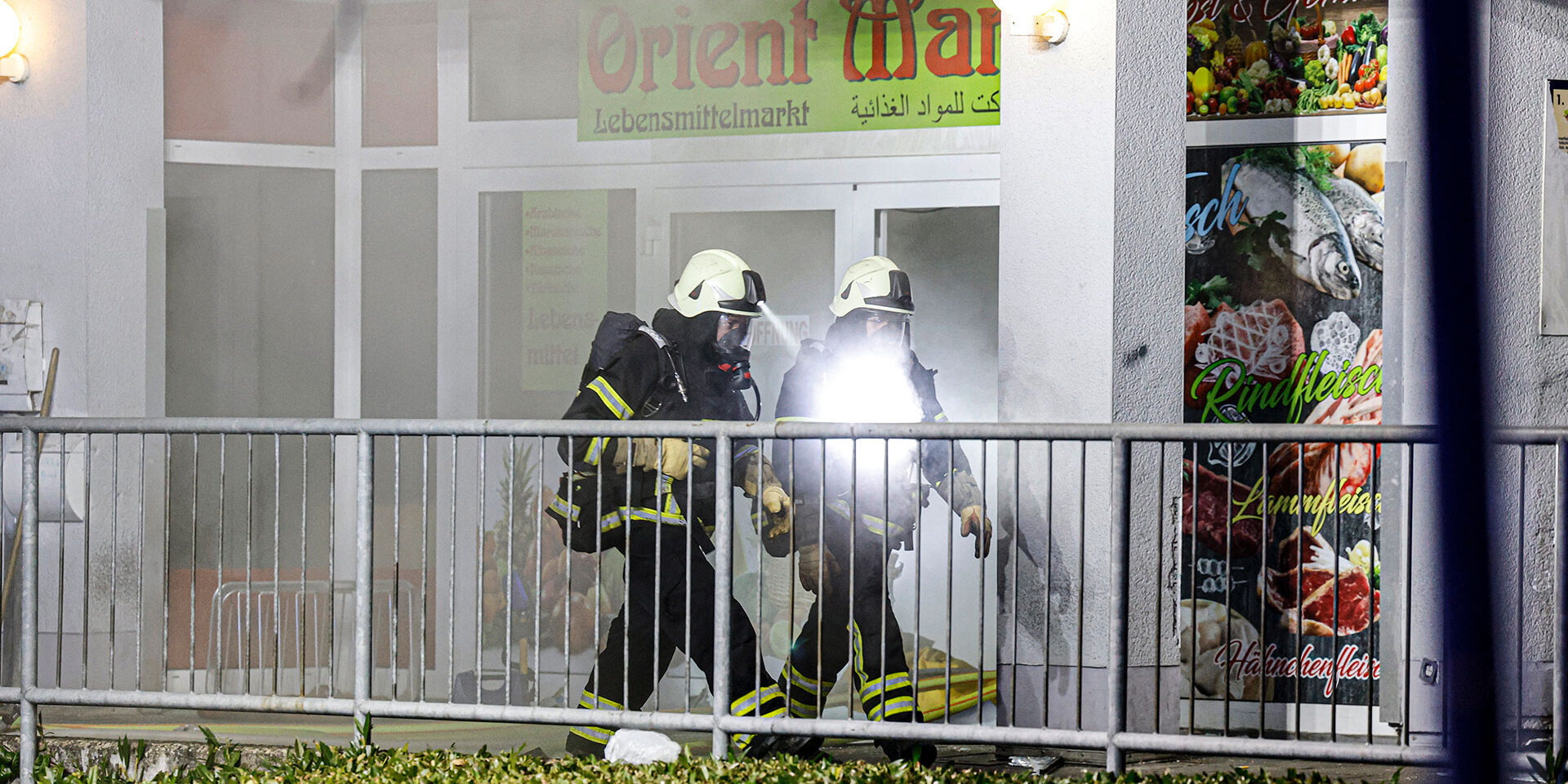 Die Feuerwehr war in der Nacht zu Sonntag an der Oststraße im Einsatz.
© Foto: Dennis Echtermann Zwei Feuerwehrleute laufen aus einem brennenden Supermarkt heraus.