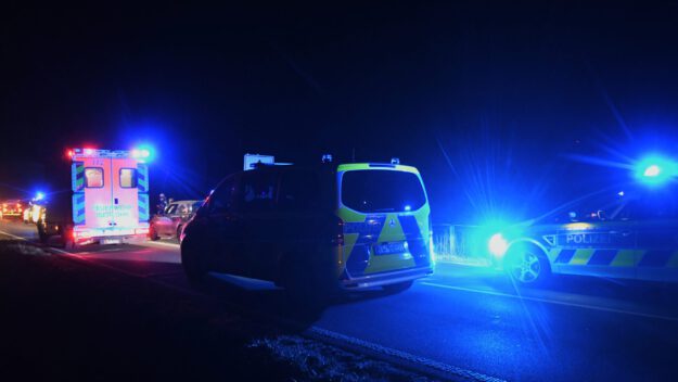 Foto: Carsten Menzel Zwei Polizeiwagen und ein Rettungswagen mit Blaulicht bei Nacht auf einer Straße.