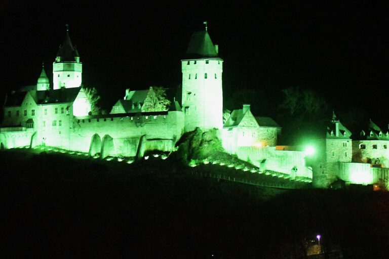 Die Burg Altena erstrahlt bei Nacht in grünem Licht.