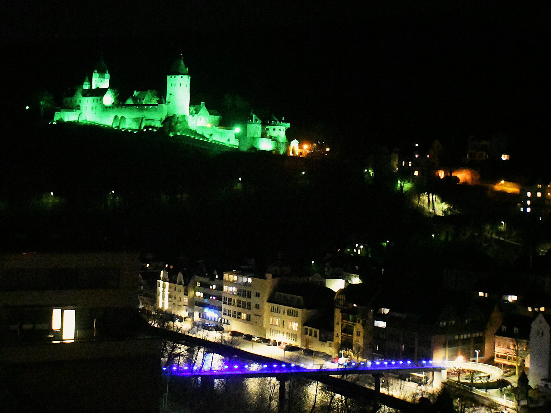 Die Burg Altena erstrahlt bei Nacht in grünem Licht.