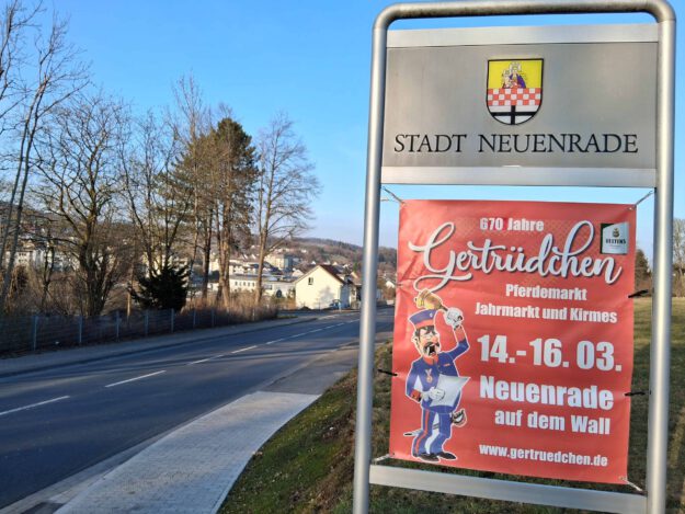 Foto: Kremer Ein Veranstaltungsplakat vom "Gertrüdchen" vor dem Ortsschild der Stadt Neuenrade.