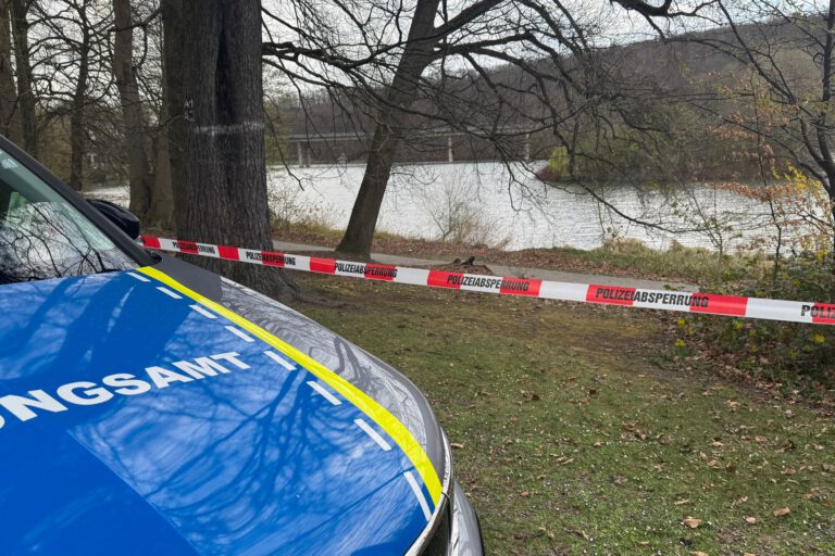 Ein Fahrzeug des Ordnungsamts steht vor einem Polizei-Flatterband. Im Hintergrund das Ufer vom Seilersee.