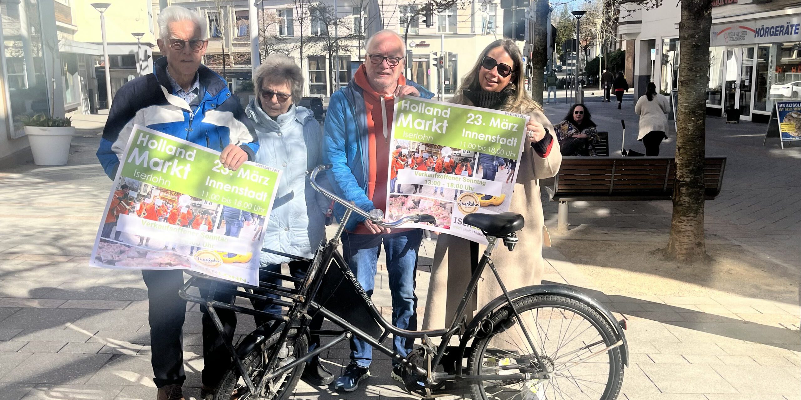 Die Organisatoren Henk und Yvonne ter Hennepe (v. li.) sowie Volker Hellhake und Kathrin Becker von der Werbegemeinschaft Iserlohn freuen sich auf den Hollandmarkt.
© Foto: Nina Tripp Vier Personen stehen in der Innenstadt und halten Werbeplakate für den Hollandmarkt in den Händen.