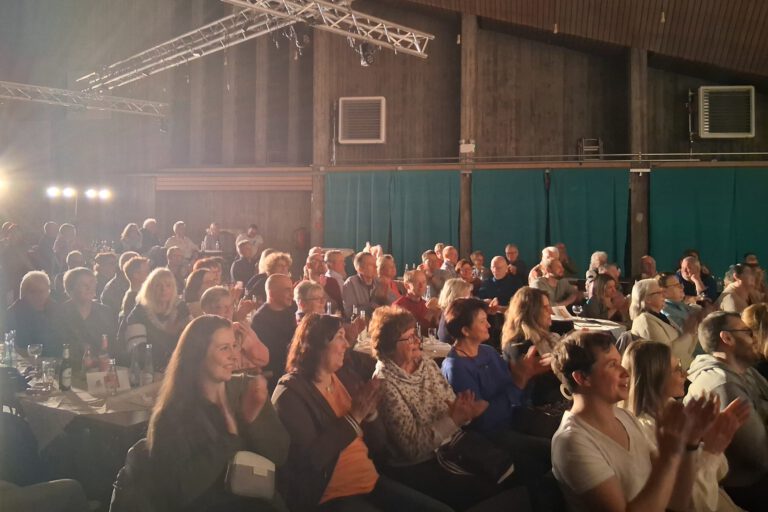 Zuschauer einer Theatervorstellung applaudieren.