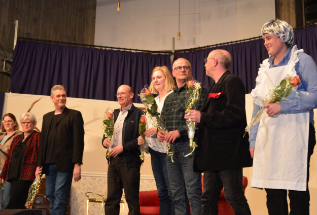 Foto: Hartmut Becker Schauspieler stehen auf der Bühne und halten Blumen in der Hand.