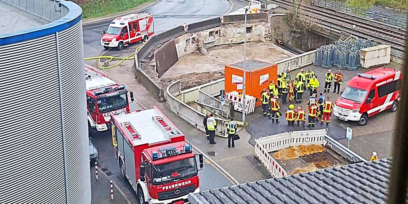 Mehrere Feuerwehrautos und Einsatzkräfte stehen vor einem Firmengebäude im Rahmen einer Übung.