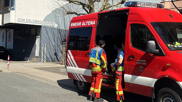 Foto: Carsten Menzel Einsatzkräfte der Feuerwehr Altena stehen an einem Einsatzfahrzeug.