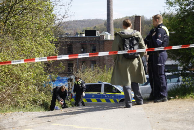 Foto: Dennis Echtermann Ermittler von der Polizei stehen hinter einer Polizeiabsperrung und untersuchen Spuren auf dem Boden.