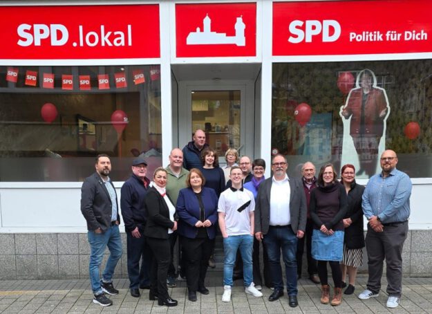 Foto: SPD Altena Ein Gruppenfoto vom Kommunalwahlteam der SPD Altena vor dem Parteibüro. Über dem Eingang steht der Schriftzug "SPD Politik für Dich".