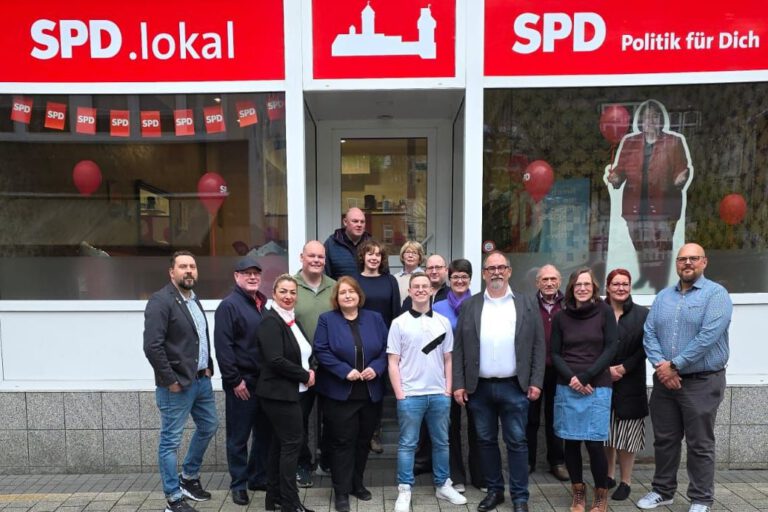 Ein Gruppenfoto vom Kommunalwahlteam der SPD Altena vor dem Parteibüro. Über dem Eingang steht der Schriftzug "SPD Politik für Dich".