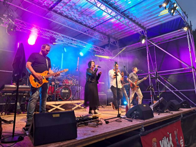 Foto: Ilka Kremer/Archiv Eine Band performt im Scheinwerferlicht auf einer Bühne.