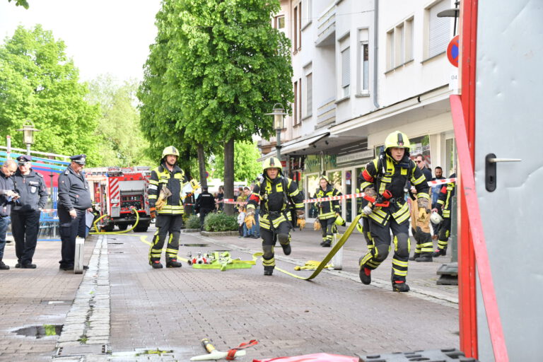 Foto: Ralf Engel Feuerwehrleute laufen mit einem Schlauch über die Hauptstraße in Hemer.