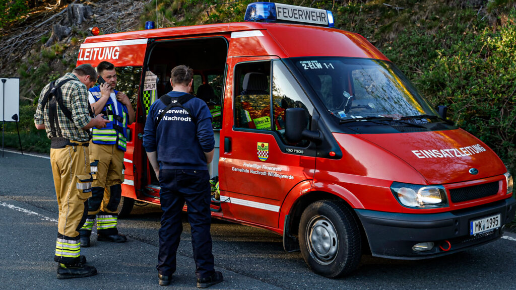 Einsatzkräfte der Feuerwehr Nachrodt-Wiblingwerde stehen vor einem Einsatzfahrzeug.