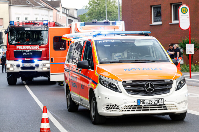 Notarzt, Rettungskräfte, Feuerwehr und Polizei stehen an der Bushaltestelle "Kiliansdom" und versorgen einen verletzten Mann.
