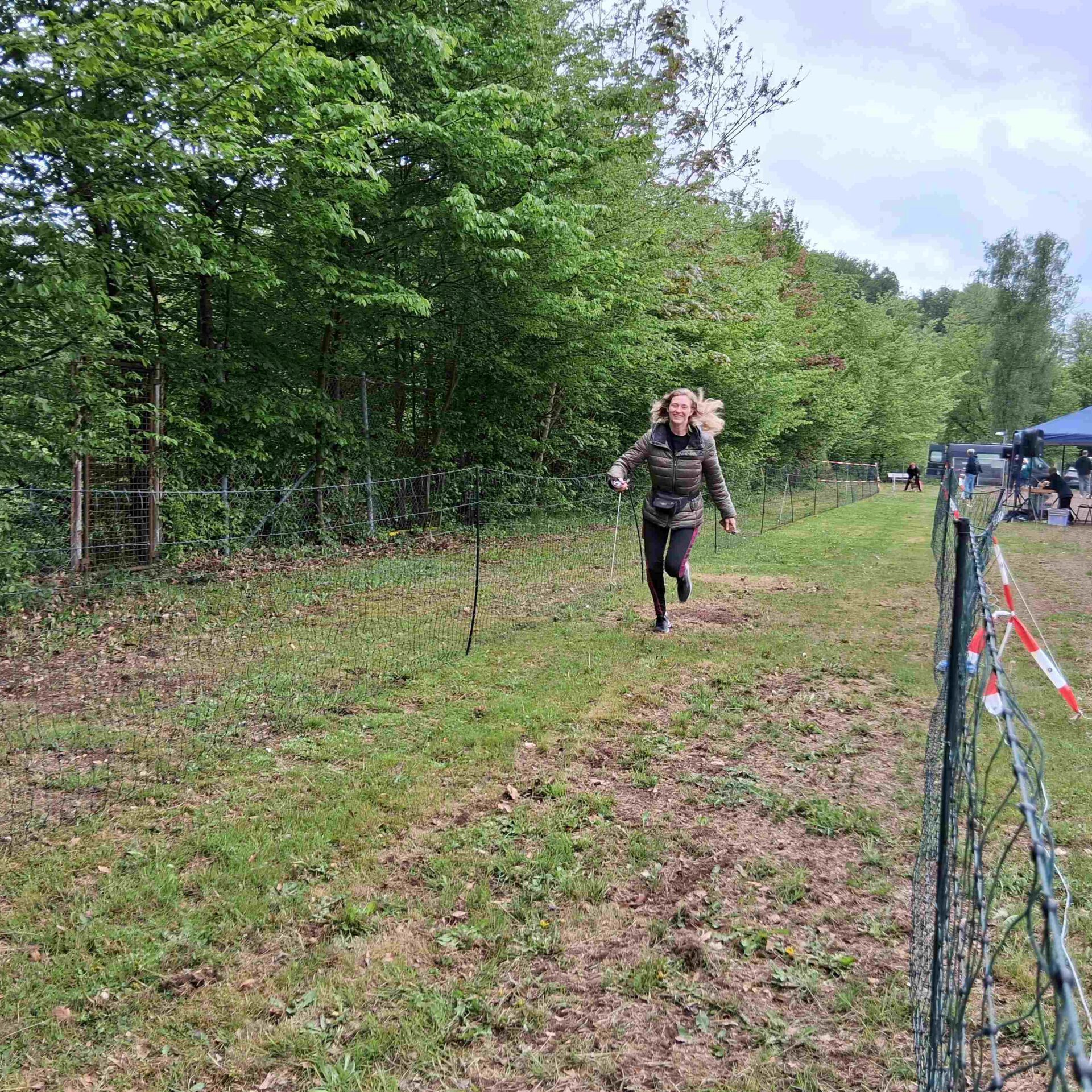 Eine Frau rennt beim Hunderennen über den Rasen.
