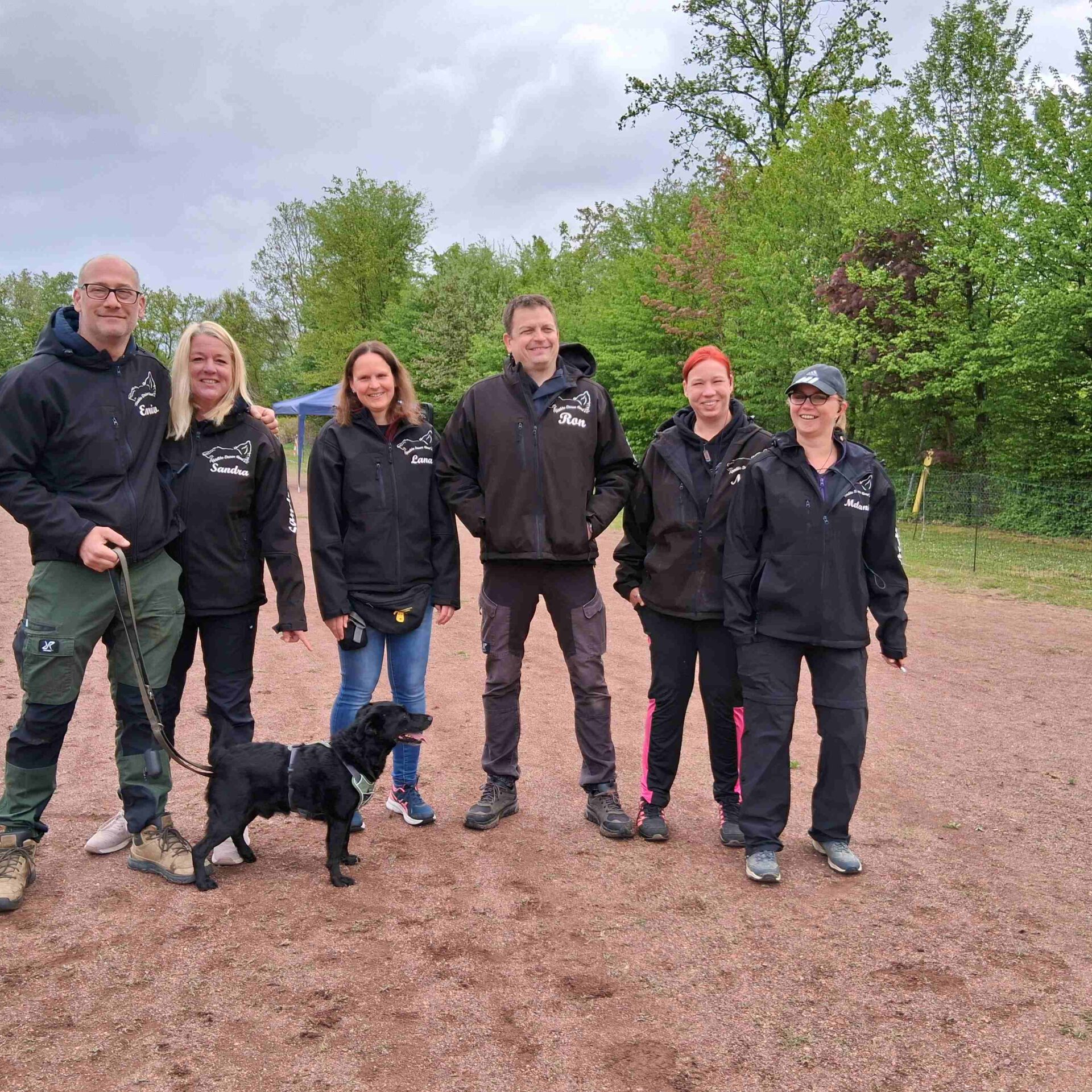 Eine Gruppe Menschen steht abseits eine Hunderennen.