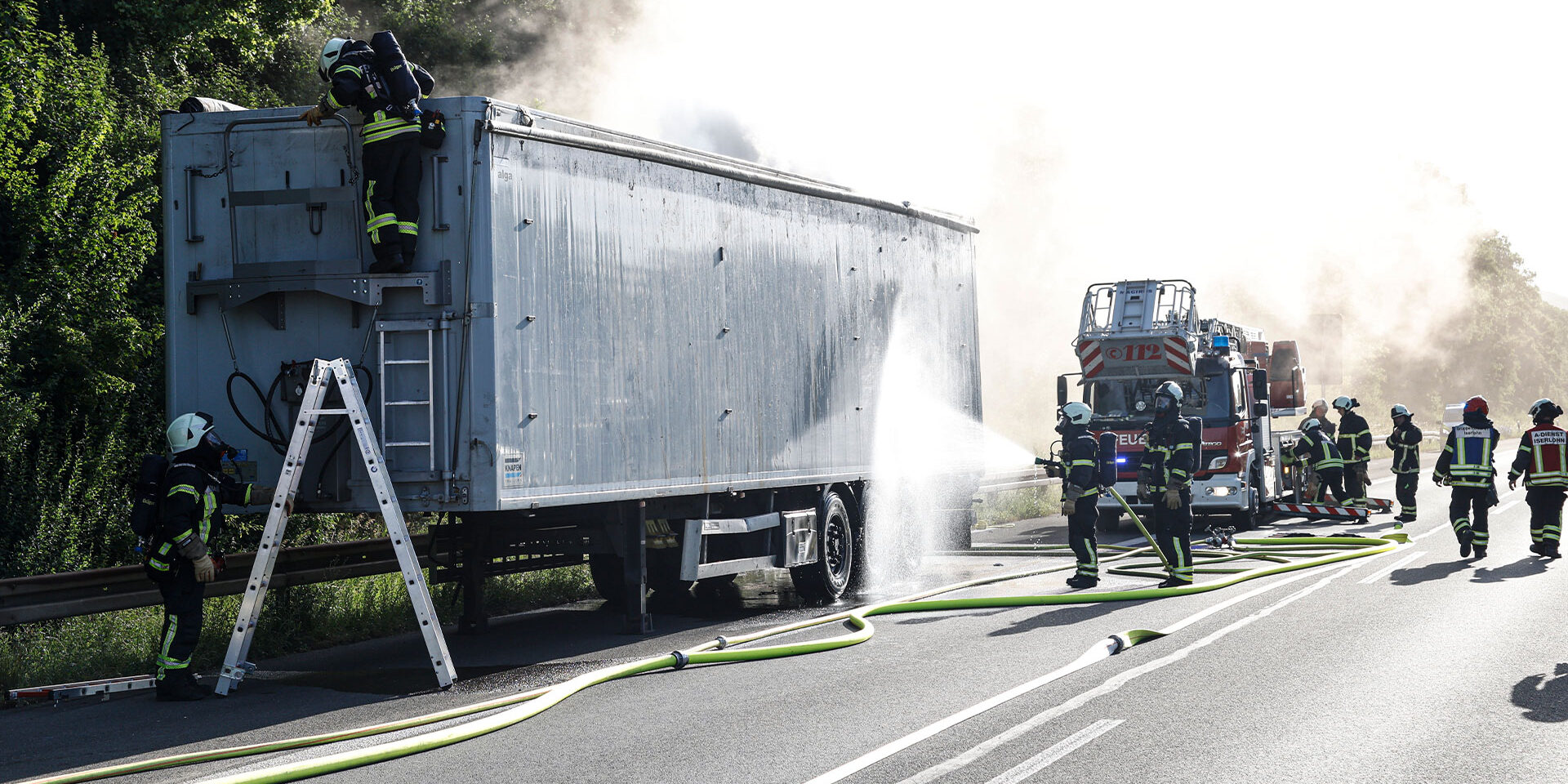 Die Feuerwehr löscht einen brennenden Lkw-Auflieger auf der Autobahn.