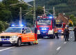 Einsatzfahrzeuge von Rettungsdienst und Feuerwehr stehen mit Blaulicht an einer Straße.
