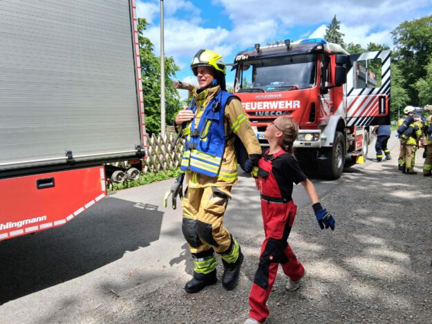 Foto.: Kremer Feuerwehrmann und feuerwehrmädchen bilden ein Team.