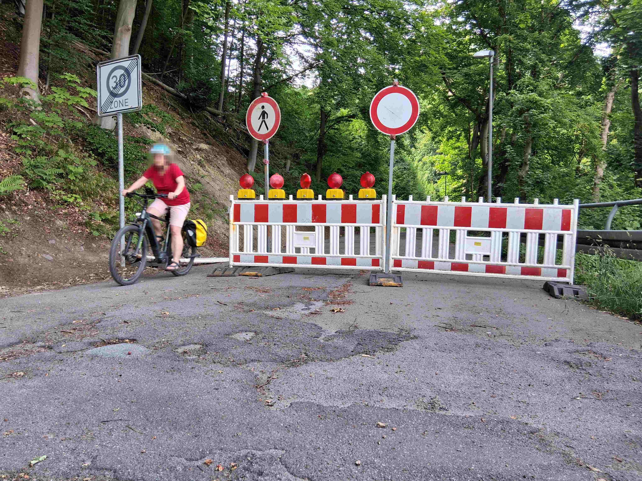 Eine Radfahrerin fährt durch die Absperrung.