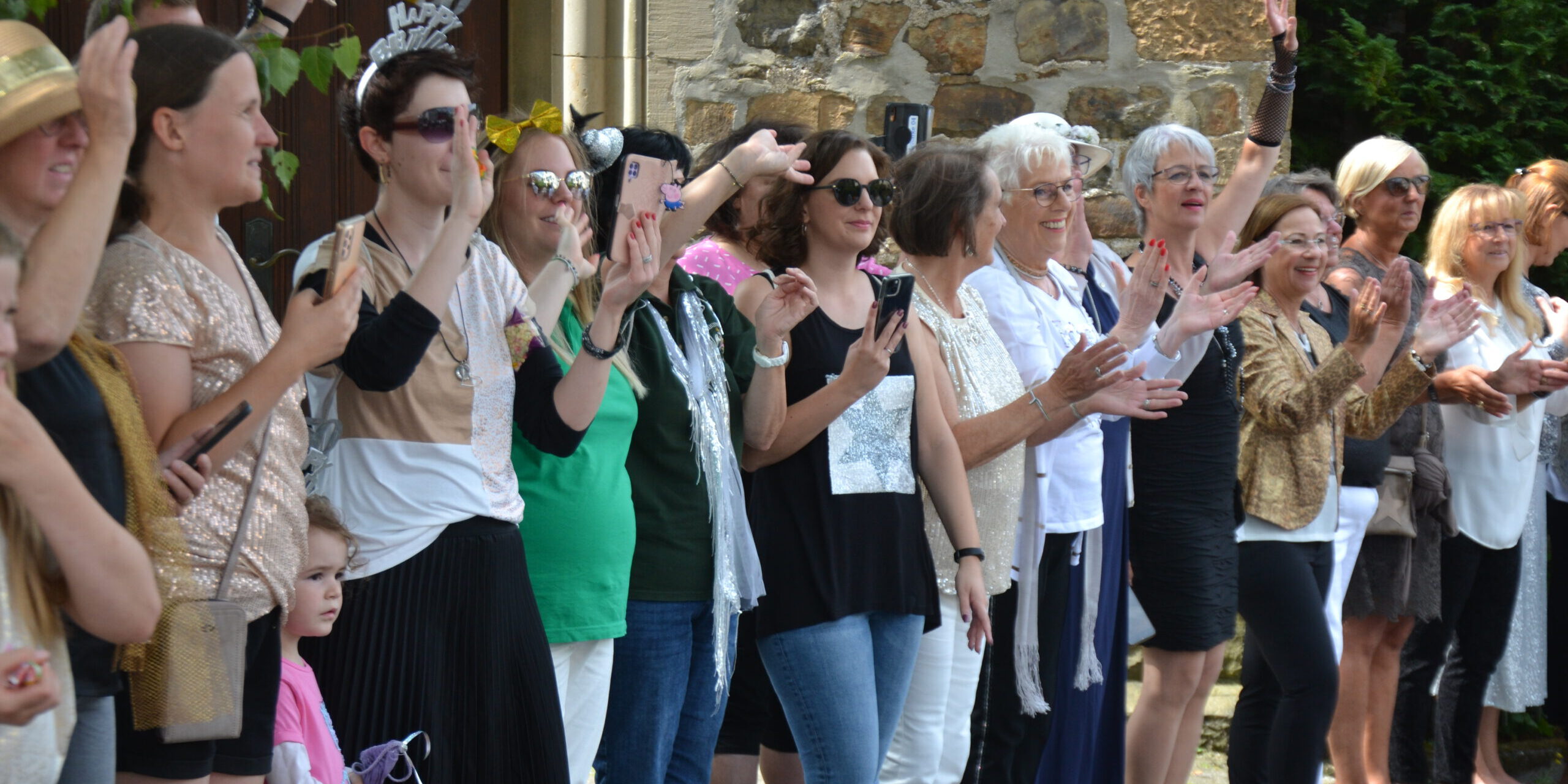 Viele Menschen stehen beim Festumzug am Straßenrand.