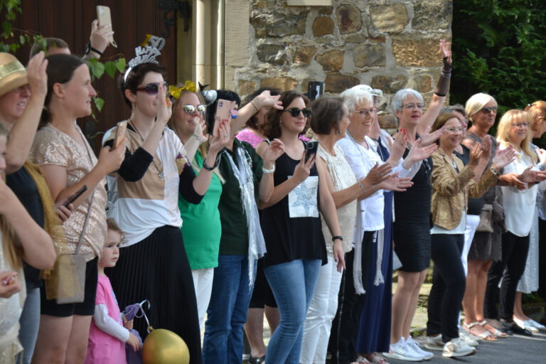 Viele Menschen stehen beim Festumzug am Straßenrand.
