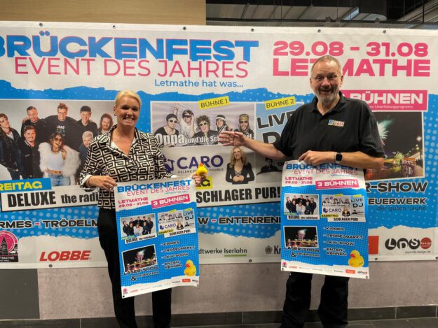 Foto: Jennifer Katz Sabrina Grigutsch und Paul Nowak halten Plakate für das Brückenfest hoch.