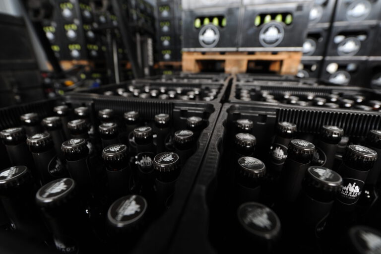 Foto: Michael May/Archiv Auf Paletten stehen aufgereiht schwarze, gefüllte Bierkästen.