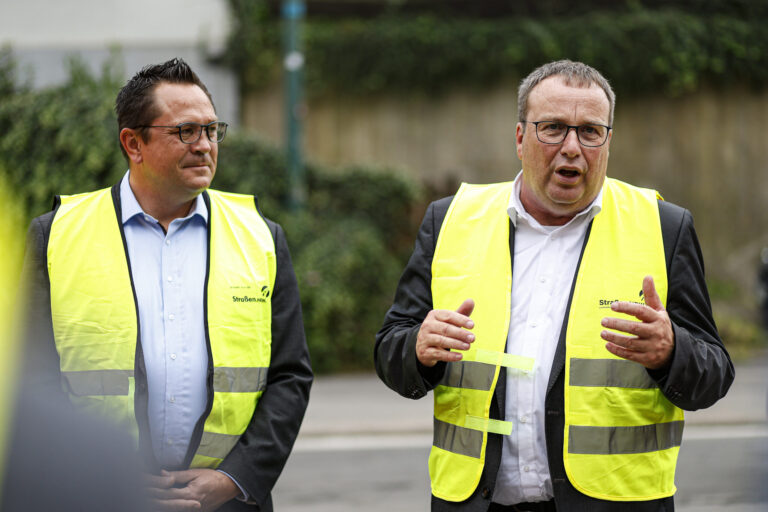 Foto: Dennis Echtermann Landrat Marco Voge und NRW-Verkehrsminister Oliver Krischer mit gelben Warnwesten über ihren Anzügen.