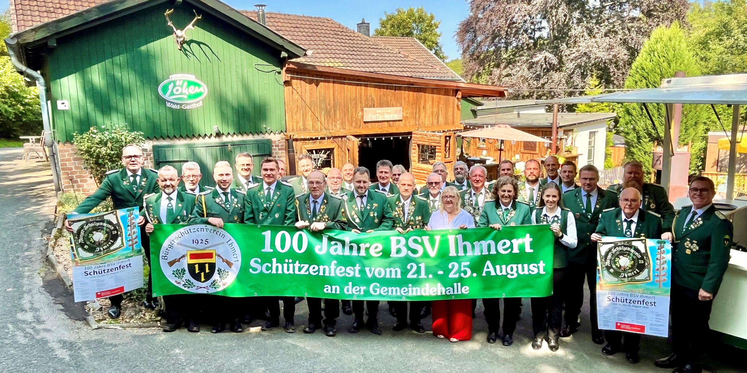 Schützen in Uniform stehen hinter einem Banner: 100 Jahre BSV Ihmert.