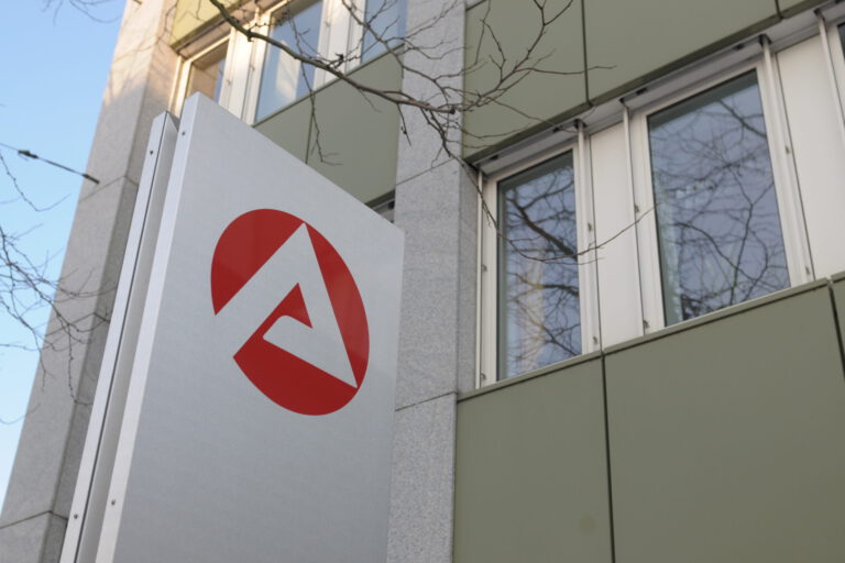 Das Logo der Agentur für Arbeit auf einer Säule vor einem Gebäude