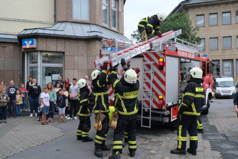 Feuerwehrleute heben eine Leiter von ihrem Einsatzfahrzeug herunter