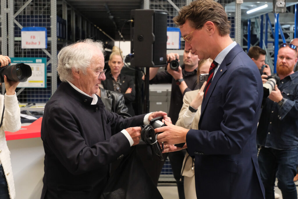 Siegfried Schulte überreicht Hendrik Wüst ein Gastgeschenk.
