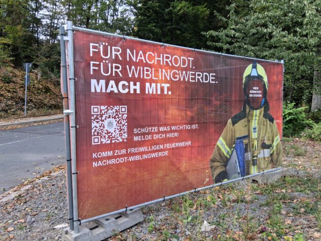 Foto: Ilka Kremer Ein Werbeschild der Feuerwehr steht an einer Straße.