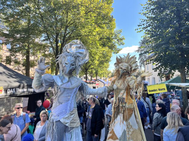 Zwei Stelzenläufer in venezianischen Karnevalskostümen in einer Menschenmenge