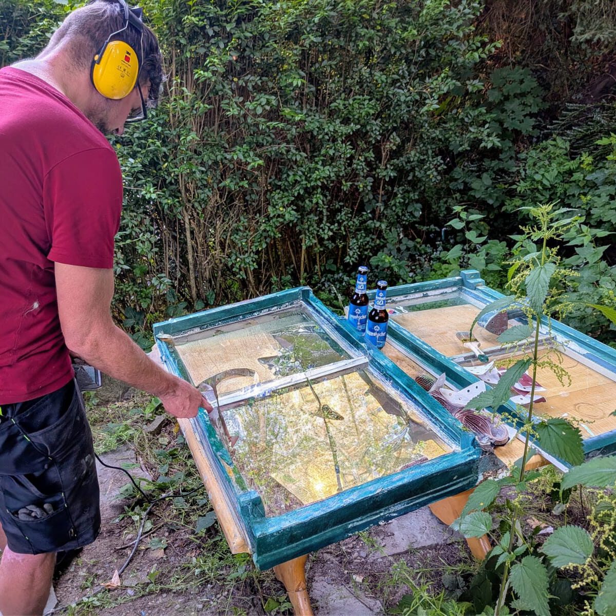 Ein Mann schleift einen Fensterrahmen.