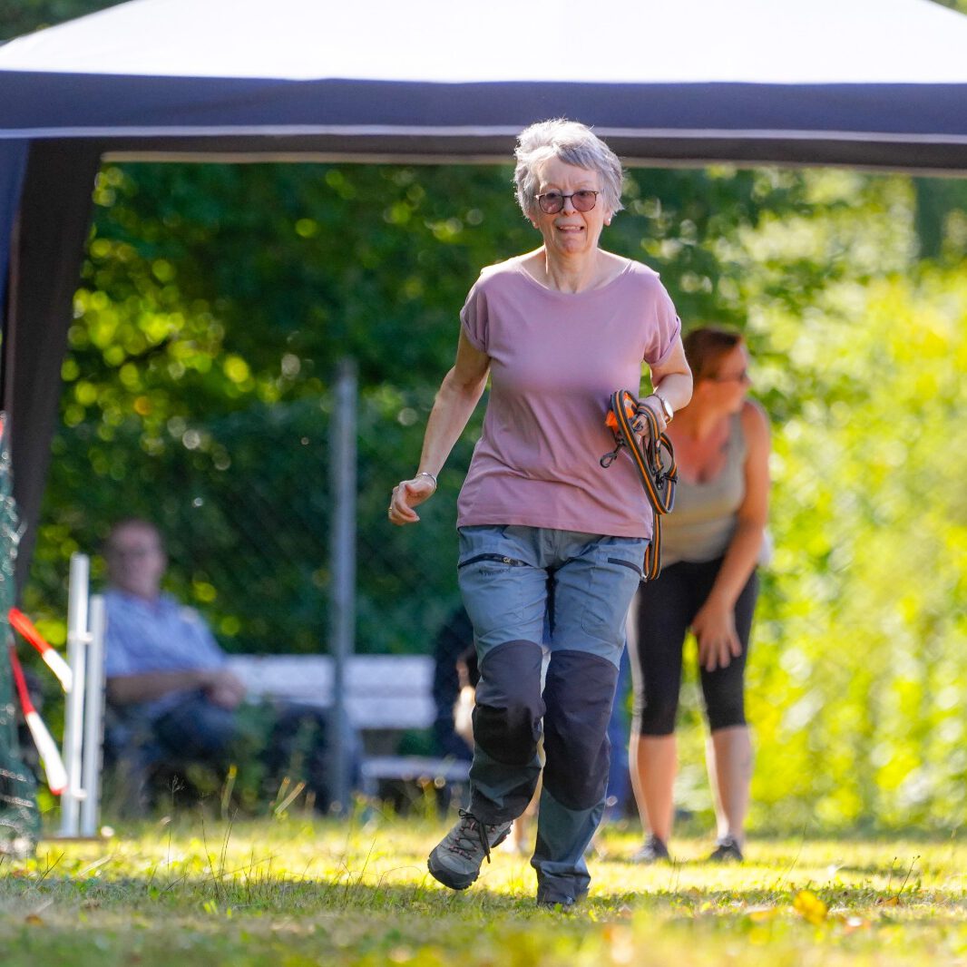 Eine Frau läuft über eine Wiese.