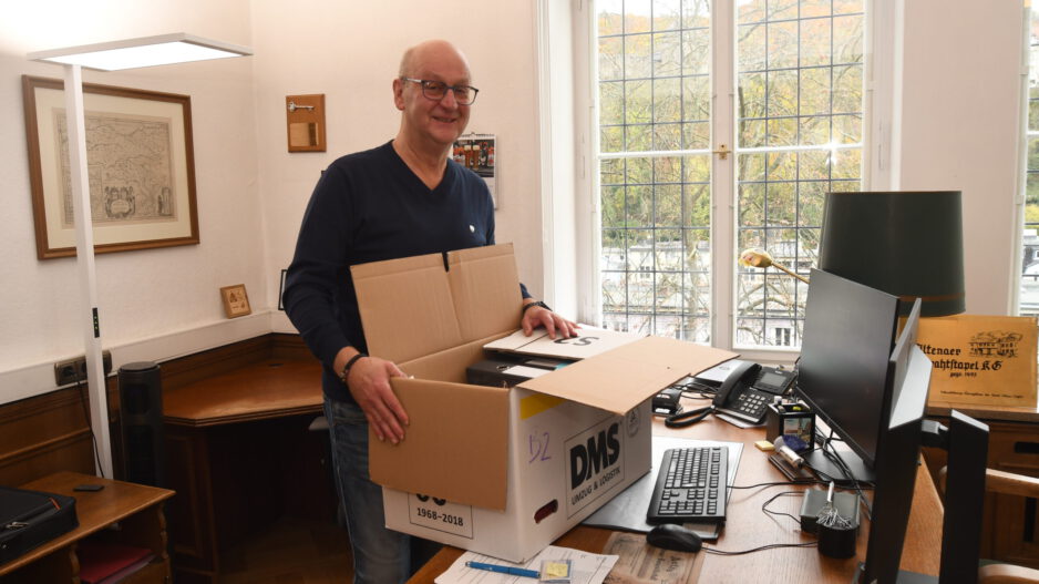 Foto: Carsten Menzel Ein Mann steht mit einem Umzugskarton an einem Behördenschreibtsich.