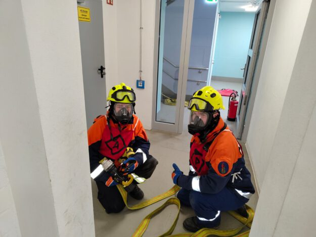 Zwei Kinder in Feuerwehrkleidung