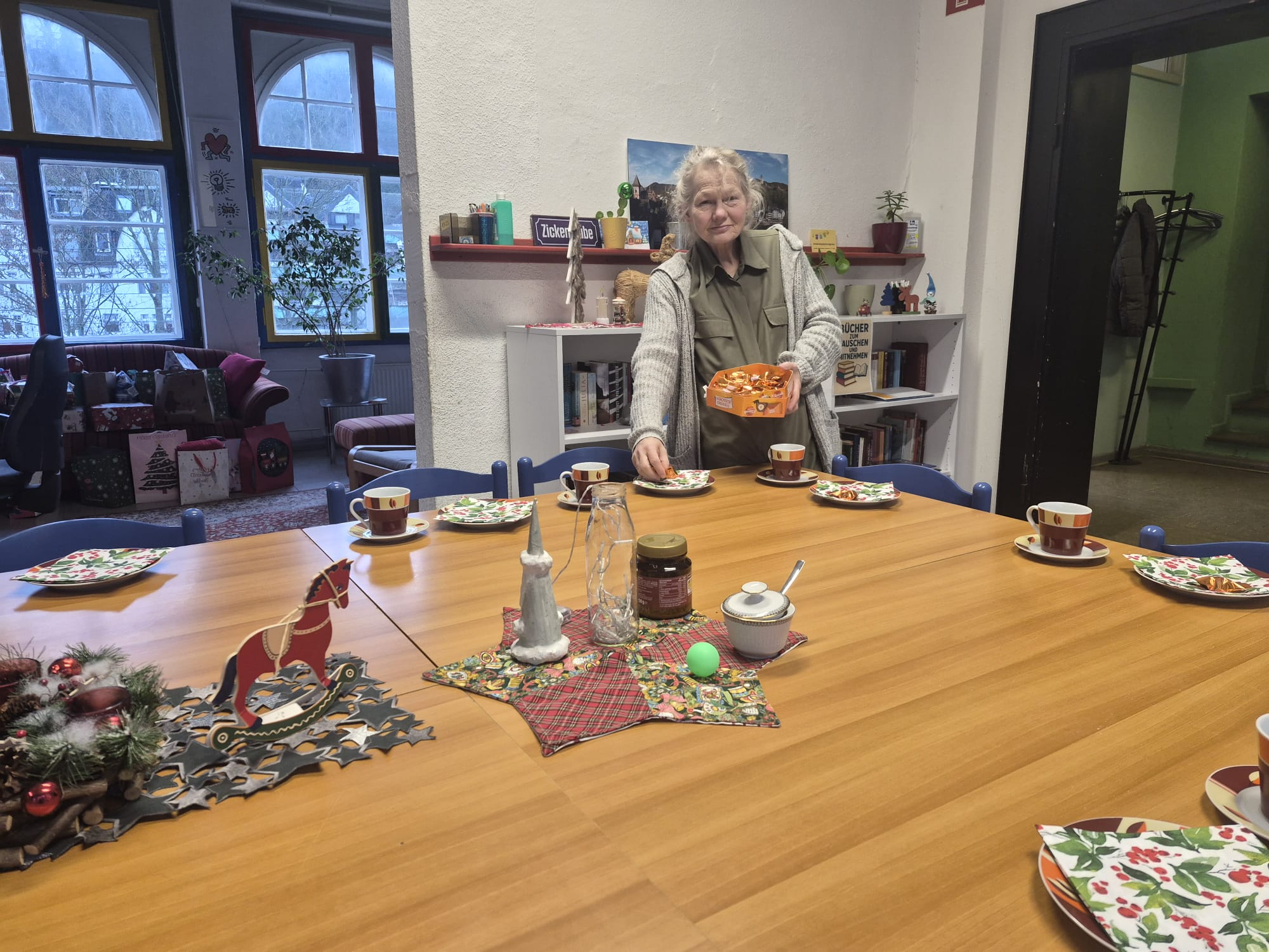 Eine Frau deckt einen Tisch.