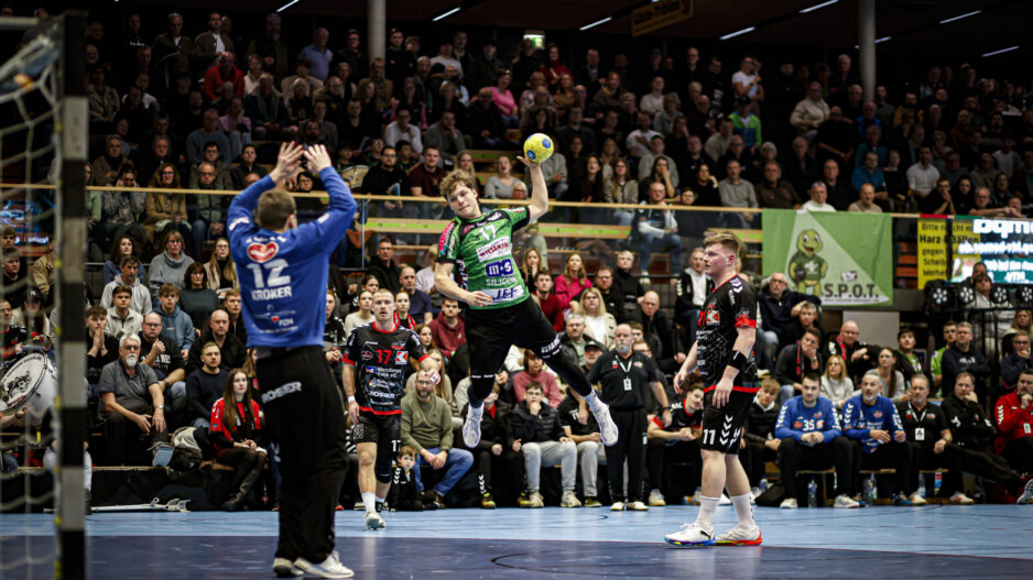 Ein Spieler des HTV beim Sprungwurf vor vollbesetzten Tribünen