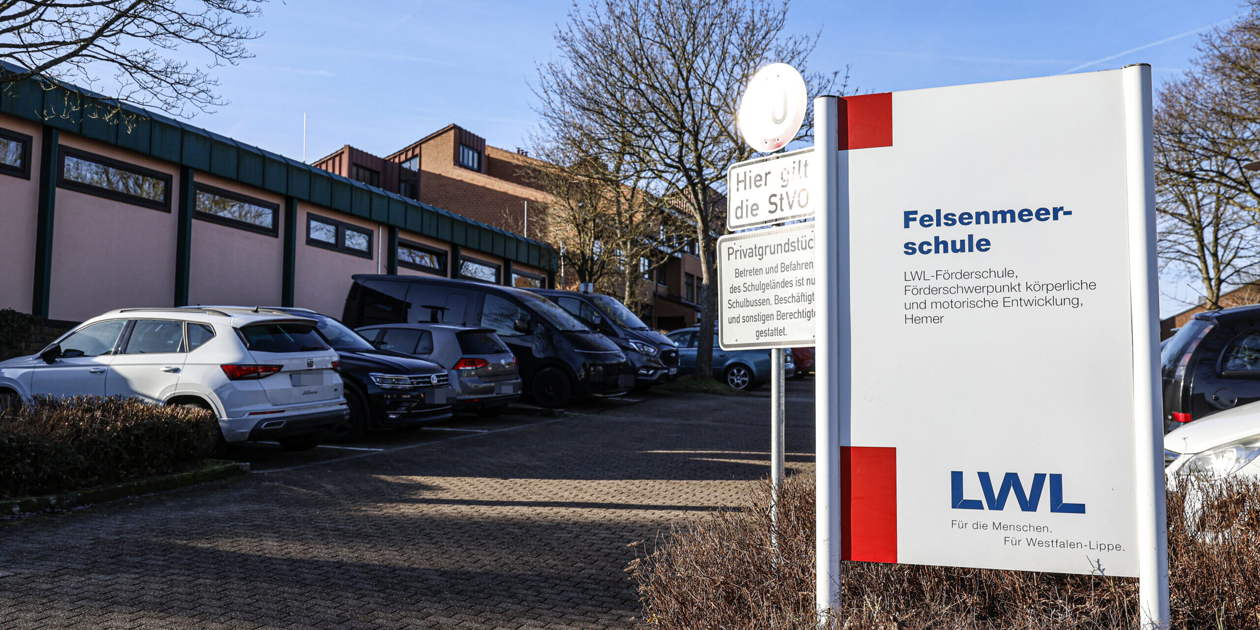 Ein Schild mit der Aufschrift "Felsenmeerschule" steht an der Einfahrt zu einem Parkplatz.