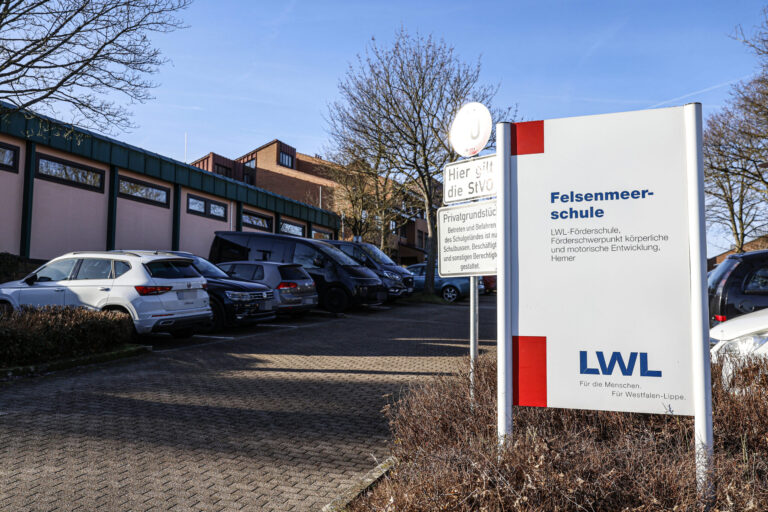 Ein Schild mit der Aufschrift "Felsenmeerschule" steht an der Einfahrt zu einem Parkplatz.