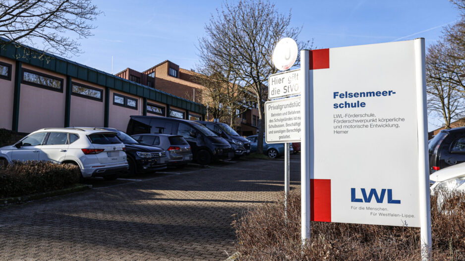 Ein Schild mit der Aufschrift "Felsenmeerschule" steht an der Einfahrt zu einem Parkplatz.