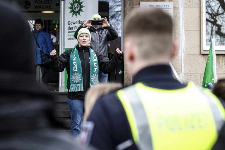GdP-Kreisvorsitzende Michelle Pfeiffer steht auf den Stufen vor dem Kreishaus in Iserlohn und hält eine Rede.